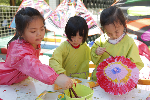 豐臺六幼的孩子們用畫筆彩繪小雨傘。