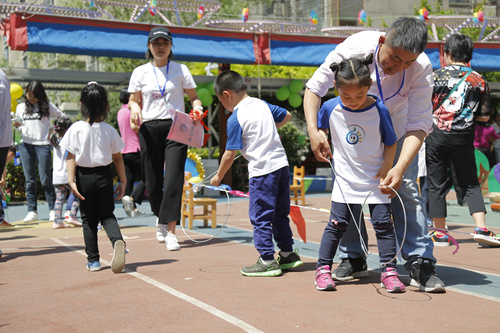 豐臺六幼的孩子們體驗推鐵環(huán)。