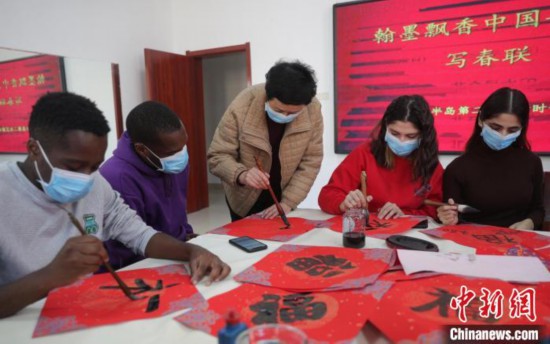 圖為書(shū)法愛(ài)好者指導(dǎo)外國(guó)留學(xué)生書(shū)寫福字?！〔芙ㄐ?攝