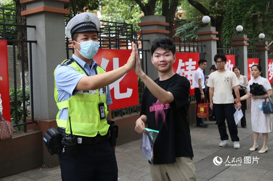 6月7日8時許，武漢中學(xué)考點門口，交警在維護秩序，並?？忌鸢耦}名。人民網(wǎng)記者 肖璐欣攝