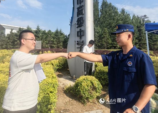 6月7日，遼寧營口老邊區(qū)消防救援大隊的消防員為高考學(xué)子加油助威。人民網(wǎng)記者 尹柏寒?dāng)z