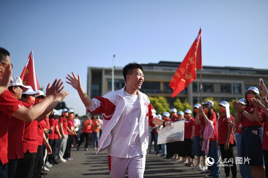 6月7日，在北京市人大附中通州校區(qū)考點，考生與送考老師擊掌加油。人民網(wǎng)記者 翁奇羽攝